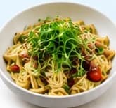 Pasta bowl topped with pea shoots